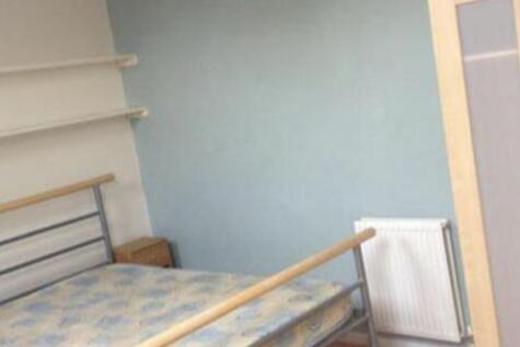 Simple furnished bedroom with a metal-framed be...