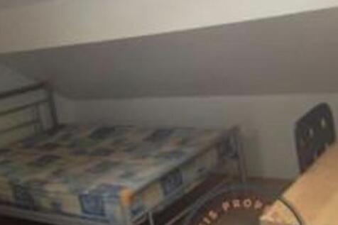 Cozy attic bedroom with a metal-frame single be...