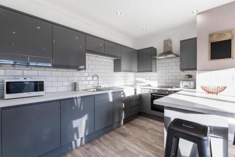 Bright modern kitchen with grey Shaker-style ca...