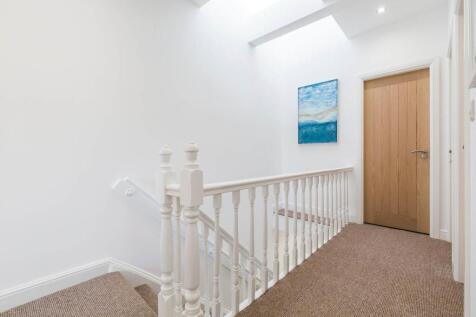 Bright, freshly painted landing with neutral ca...