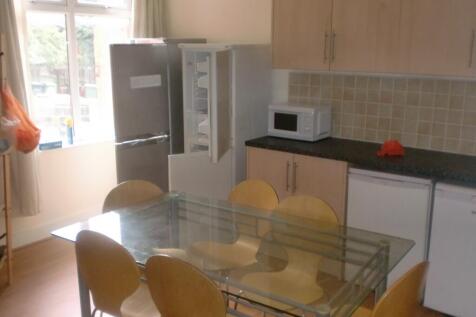 Bright kitchen with a glass dining table and si...