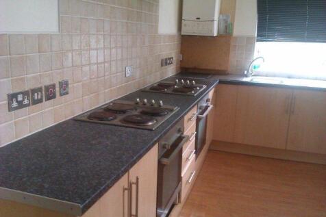 Modern galley-style kitchen with laminate floor...