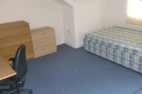 Simple furnished bedroom with a single bed, des...