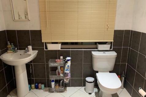 Well-kept bathroom with pedestal sink, toilet a...