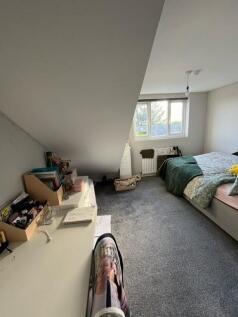 Bright, cozy bedroom with sloped ceiling, large...