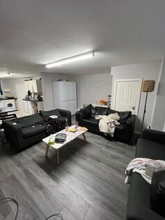 Contemporary communal lounge with multiple sofa...