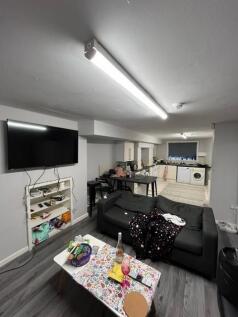 Open-plan living area with a wall-mounted TV, c...