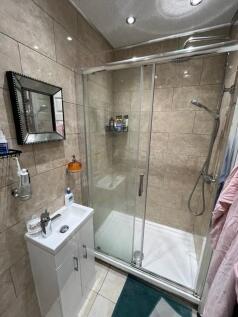 Well-presented tiled bathroom with a glass-encl...