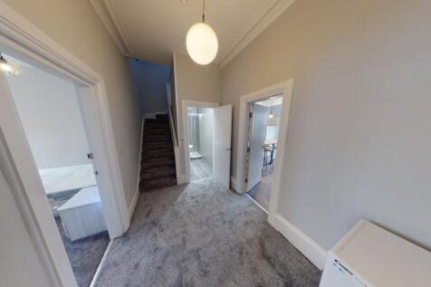 Bright, carpeted hallway with neutral decor, hi...