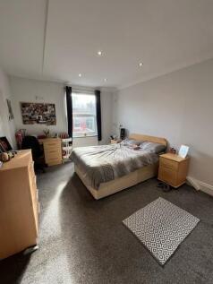 Bright, tidy bedroom featuring a comfortable do...