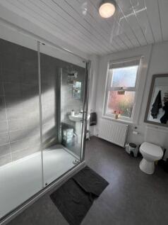 Bright, modern bathroom with a large glass show...