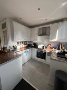 Modern fitted kitchen with white cabinets, inte...