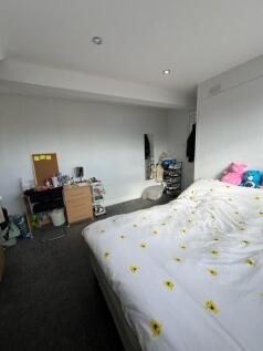 Bright, simply furnished bedroom with a double ...