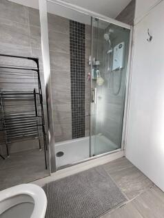 Modern tiled bathroom featuring a glass-enclose...