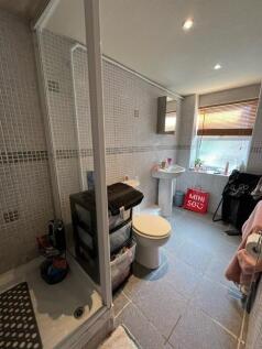 Well-lit bathroom with a walk-in shower, pedest...