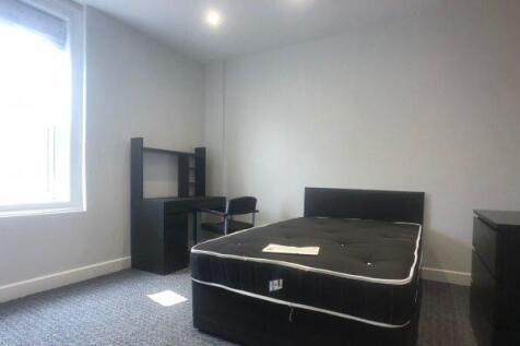 Bright, simply furnished bedroom with a large w...