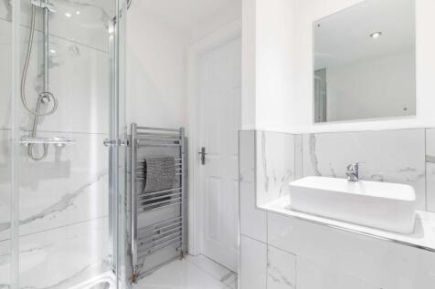 Bright, modern bathroom with a glass shower enc...