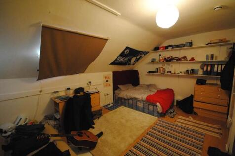 Cozy attic bedroom with angled ceilings, a sing...