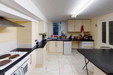 Well-equipped communal kitchen with multiple wo...