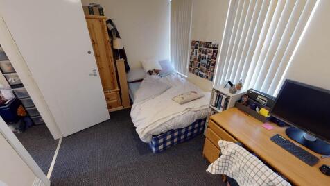 Cozy single bedroom with a neatly made bed, bui...