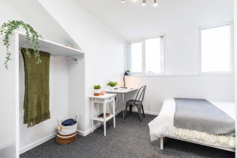 Bright, neatly furnished single bedroom with a ...