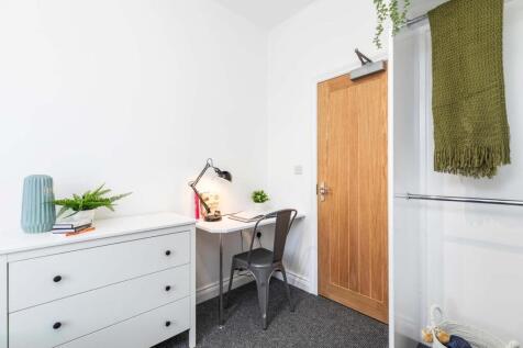 Bright, tidy bedroom with a compact study area,...