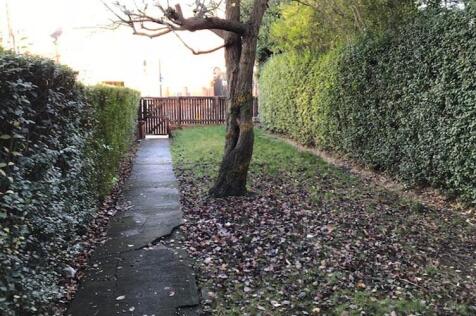 Private rear garden with a paved path, mature t...