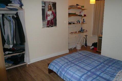 Cozy bedroom with wooden flooring, shelving for...