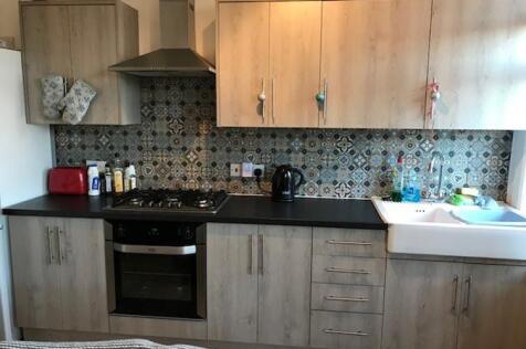 Contemporary kitchen with patterned tiled splas...