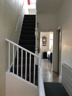 Bright, tidy hallway with a carpeted staircase ...