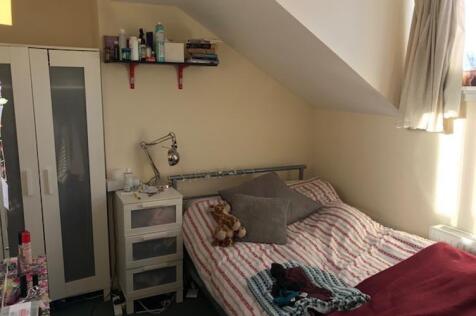 Cosy attic bedroom with a sloped ceiling, fitte...