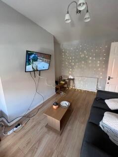 Contemporary living room with a wall-mounted TV...