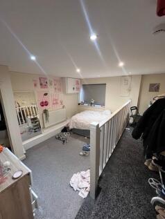 Bright, carpeted bedroom with a double bed tuck...