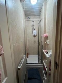 Compact, fully tiled shower room with a framed ...