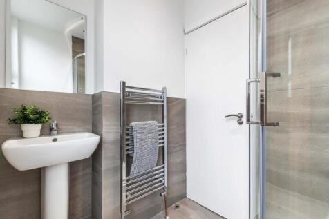Bright, modern bathroom with a pedestal sink, h...