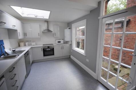 Bright modern kitchen with white cabinetry, int...