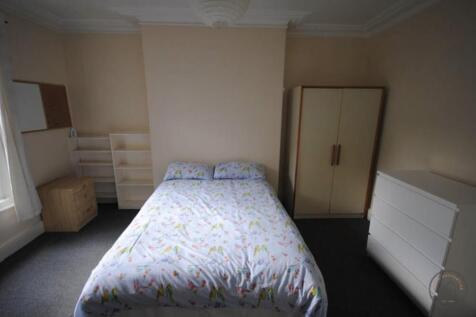 Bright, simply furnished bedroom with a double ...