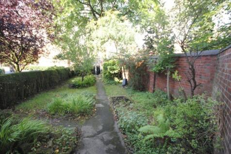 Attractive leafy garden with a central paved pa...
