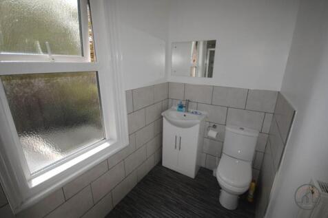 Bright, modern bathroom with tiled walls, a van...