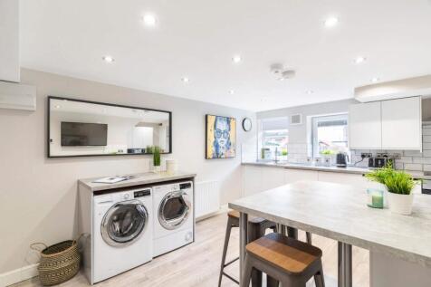 Bright modern kitchen with integrated appliance...