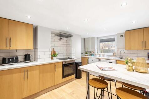 Bright modern kitchen with warm wood cabinetry,...