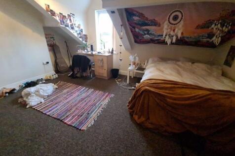 Cozy attic bedroom with sloped ceilings, a comf...