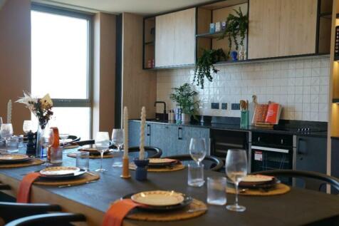A modern kitchen with a dining area, featuring ...