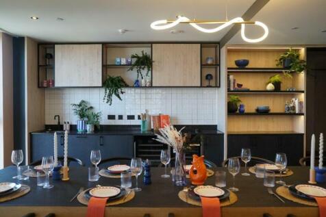A modern, clean kitchen featuring a dining area...