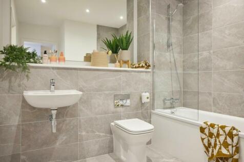 A clean and modern bathroom featuring a bath an...