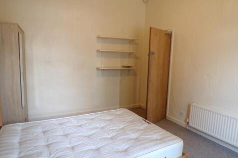 A spacious and tidy double bedroom with neutral...