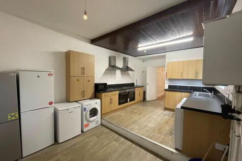 A spacious and modern kitchen equipped with ess...