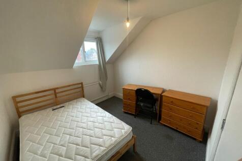 A spacious and bright double bedroom with a des...