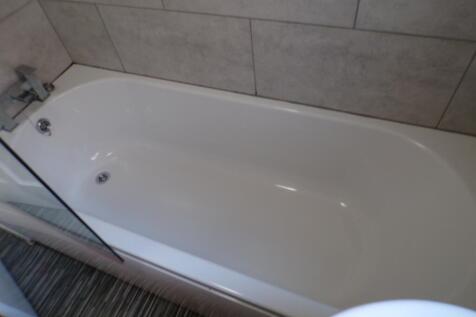 A modern bathroom featuring a sleek bathtub, pe...