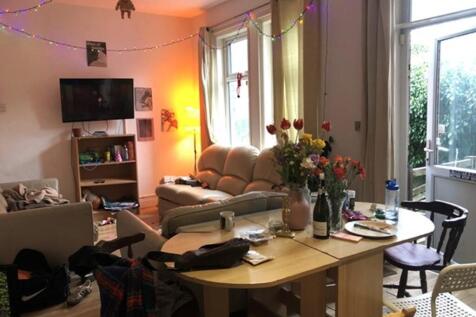 A spacious and vibrant living room filled with ...
